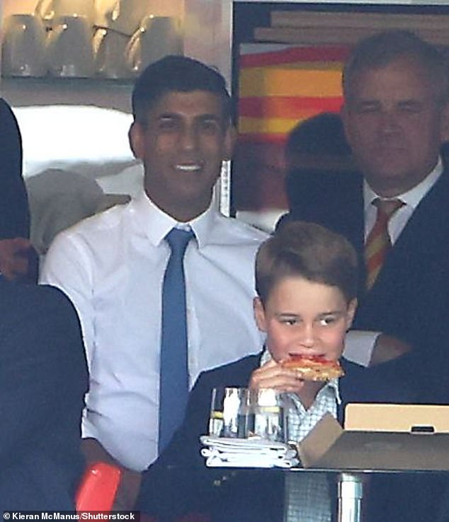 Prince George enjoys a large slice of pizza as his father speaks to then Prime Minister Rishi Sunak at the England vs Australia cricket match during The Ashes last year.