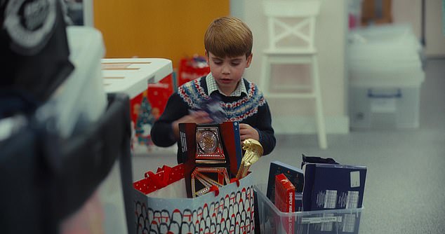 Louis, who also volunteers at the baby bank, struggles to contain his excitement as he rummages through a selection of shiny new toys.