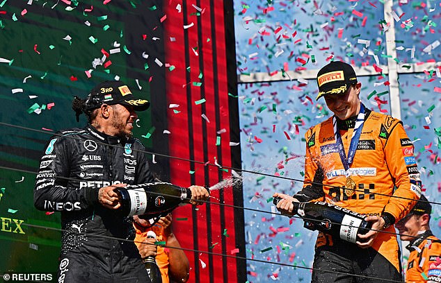 Piastri (right) and Hamilton (left) pictured spraying each other with champagne on the podium