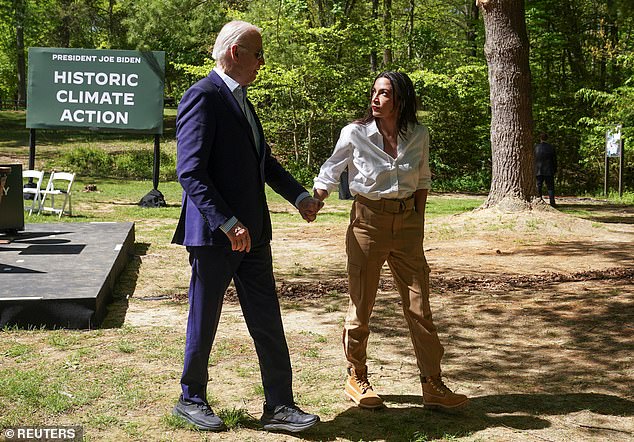 U.S. President Joe Biden and U.S. Representative Alexandria Ocasio-Cortez (D-N.Y.) hold hands at an event to mark Earth Day during a visit to Prince William Forest Park in Triangle, Virginia, U.S., April 22, 2024.