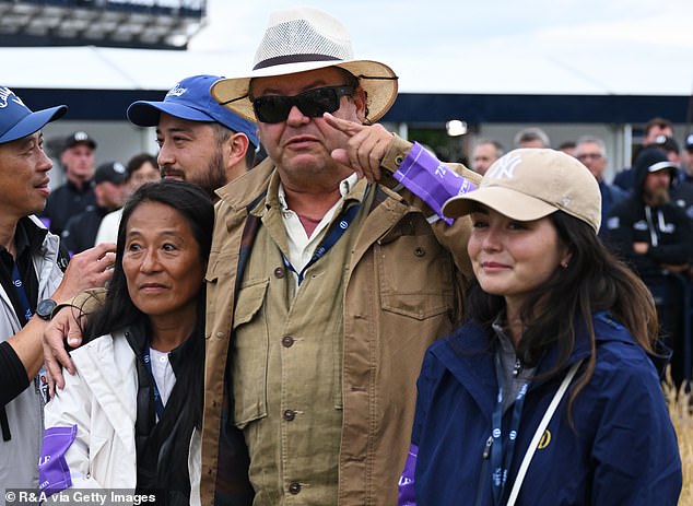 Maya looked excited as she waited to greet her husband on the 18th green.