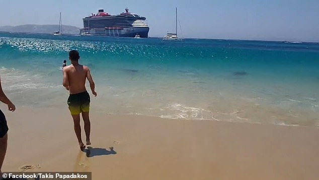 You can see a wall of water forming and then collapsing on a woman still in the sea.