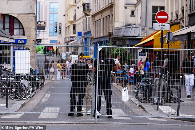 Police officers guard metal railings on the streets of Paris