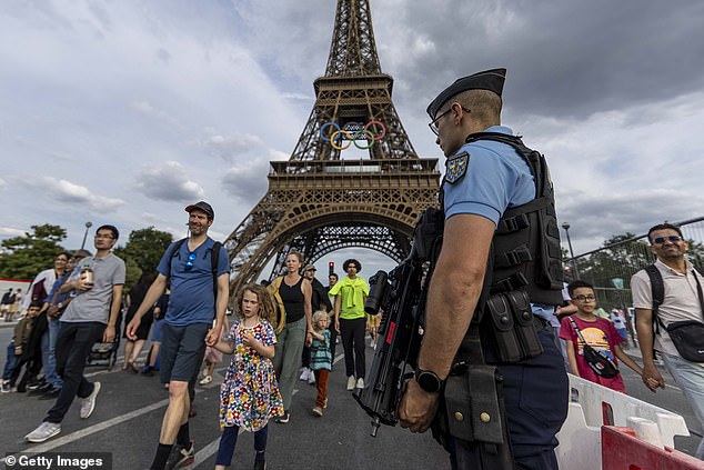 A policeman stands guard on the bridge near the Eiffel Tower on July 17, 2024 in Paris, France