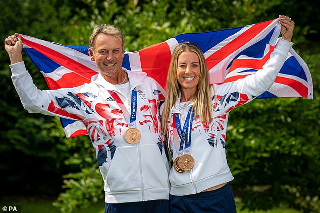 Hester (left) and Charlotte Dujardin (right) raise the Union flag to celebrate their medals at Tokyo 2020