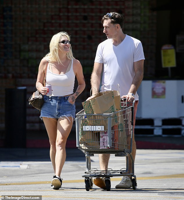 She cut a casual figure in a low-cut white tank top and tiny denim shorts.