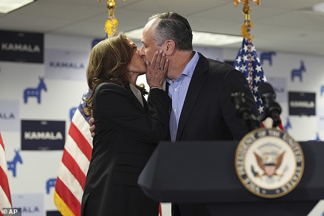 Vice President Kamala Harris (left) kisses her husband, second gentleman Doug Emhoff (right), before delivering remarks Monday at the Wilmington, Delaware, campaign headquarters she inherited from President Joe Biden.