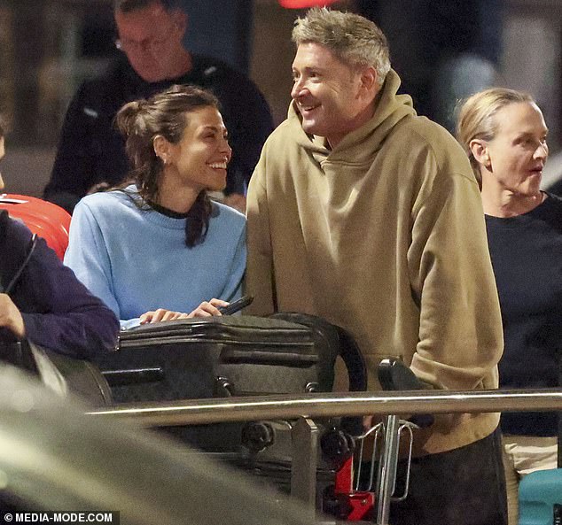 They were all smiles as they arrived home, with Arabella, 32, hugging the former cricket captain as she pushed her four suitcases.