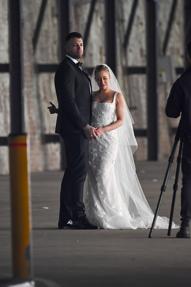 He wore purple flowers pinned to his lapel and smiled for the cameras as the nuptials got underway.