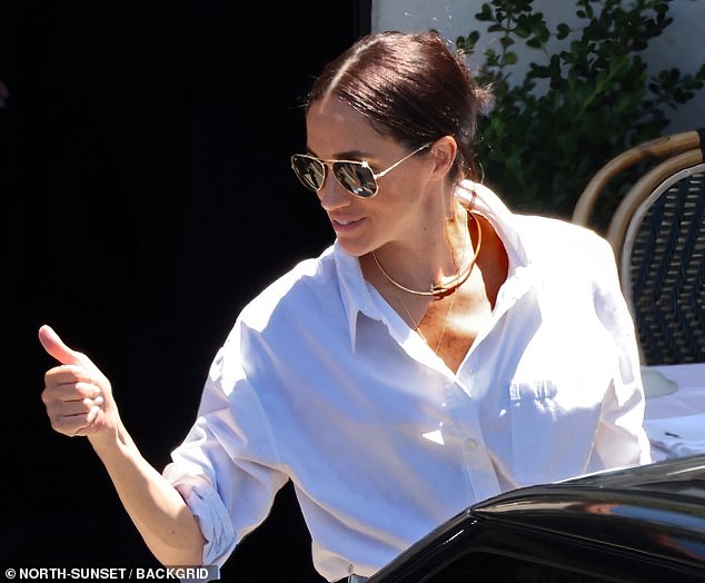 Meghan, who was pictured giving Kimberly a thumbs-up, has been seen wearing her £15,500 Cartier necklace on previous occasions.