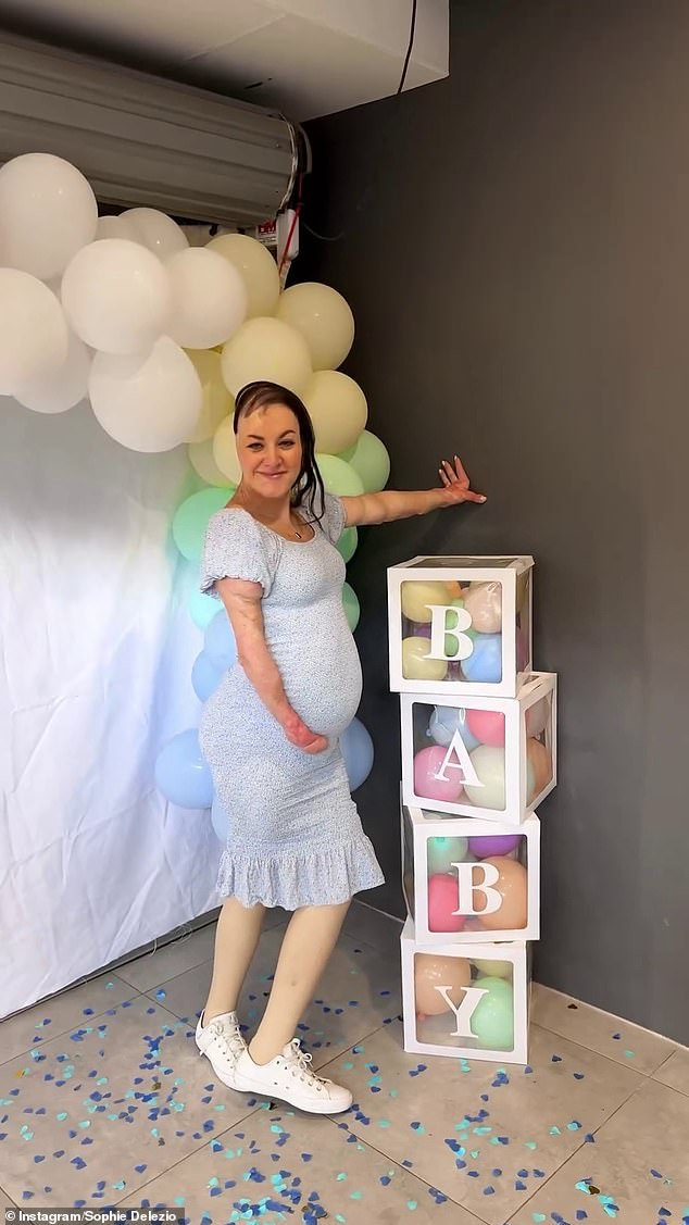 The mom-to-be donned a form-fitting blue dress to mark the baby's gender, cradling her bump as she posed next to baby blocks.