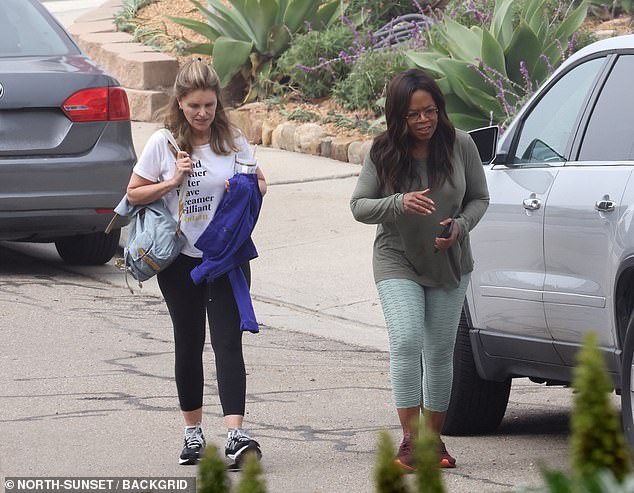 Oprah looked slender in a long-sleeved, gray-green shirt that hung loosely on her.