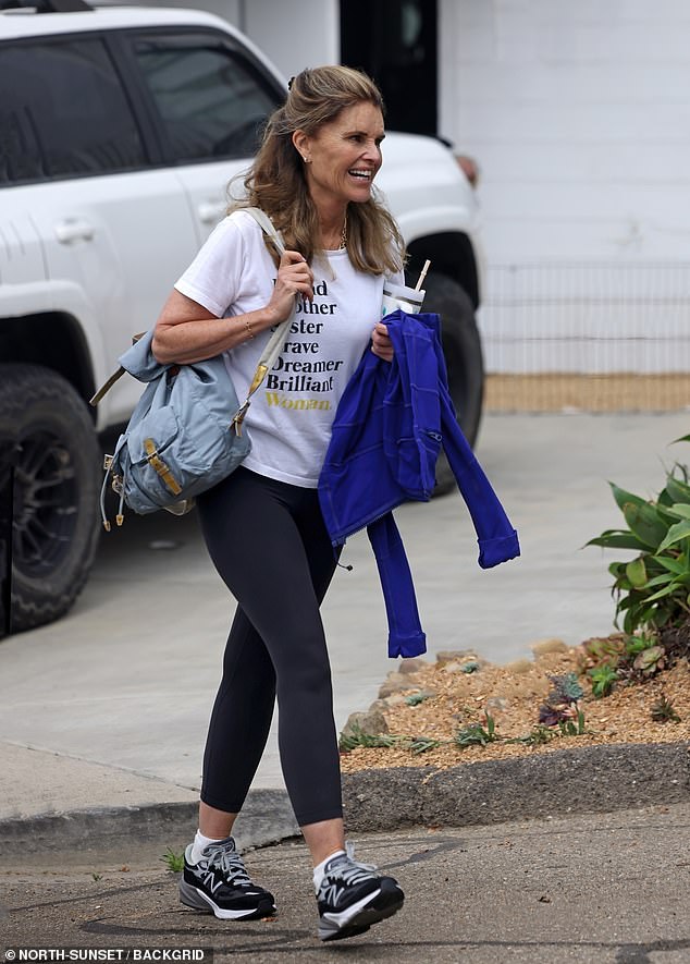 She kept comfortable in her black, white and grey New Balance sneakers, and had her arms full with a pale blue purse, a royal blue jacket and a large water bottle.