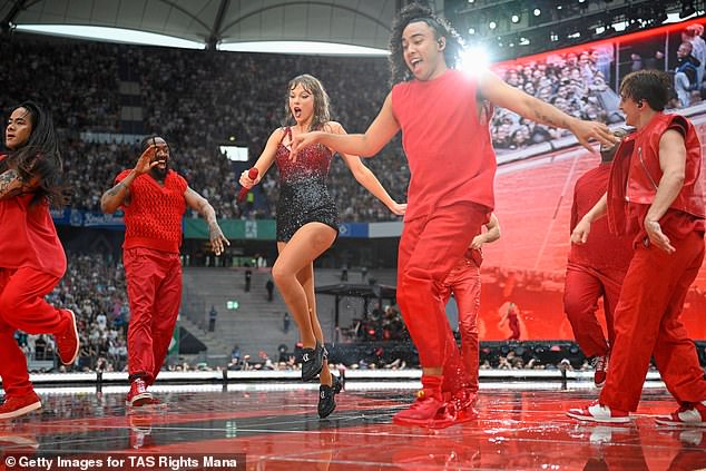 She wore her usual bright red and black jumpsuit as she performed the hit 22 at a very rainy show.