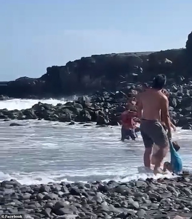 Parents are seen dragging their children as a violent fight takes place in front of them.