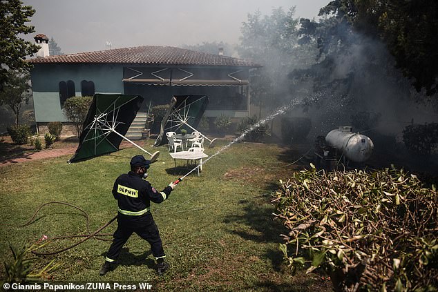 Firefighters here try to extinguish a fire inside the courtyard of a house in the suburb of Trilofos, near the city of Thessaloniki, Greece, July 18, 2024.