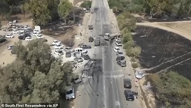 Burned and damaged cars lie along a desert road after an attack by Hamas militants on the Tribe of Nova Trance music festival near Kibbutz Re'im in southern Israel on Saturday, October 7.