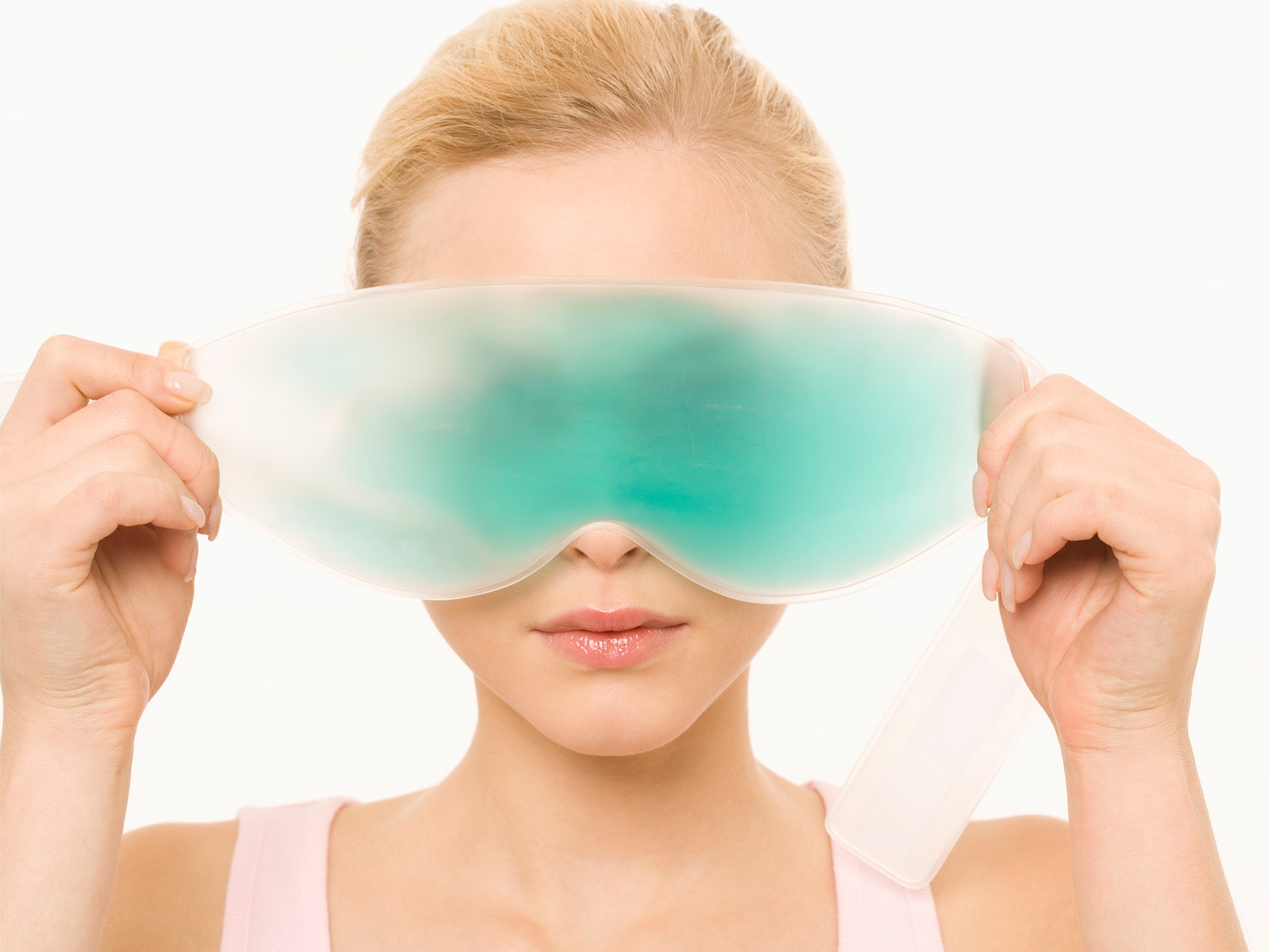 Person holding a cooling gel pad in front of their eyes.