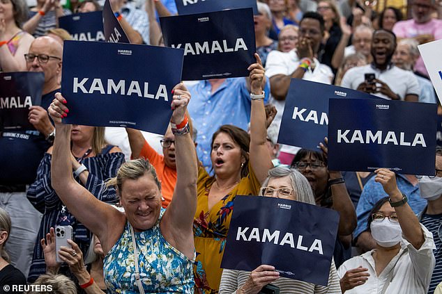 People hold signs in support of U.S. Vice President Kamala Harris as she speaks at a campaign event at West Allis High School in West Allis, Wisconsin, on July 23.