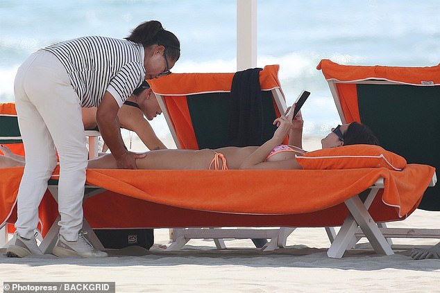 She was looking at something on her phone while getting the massage on the beach.