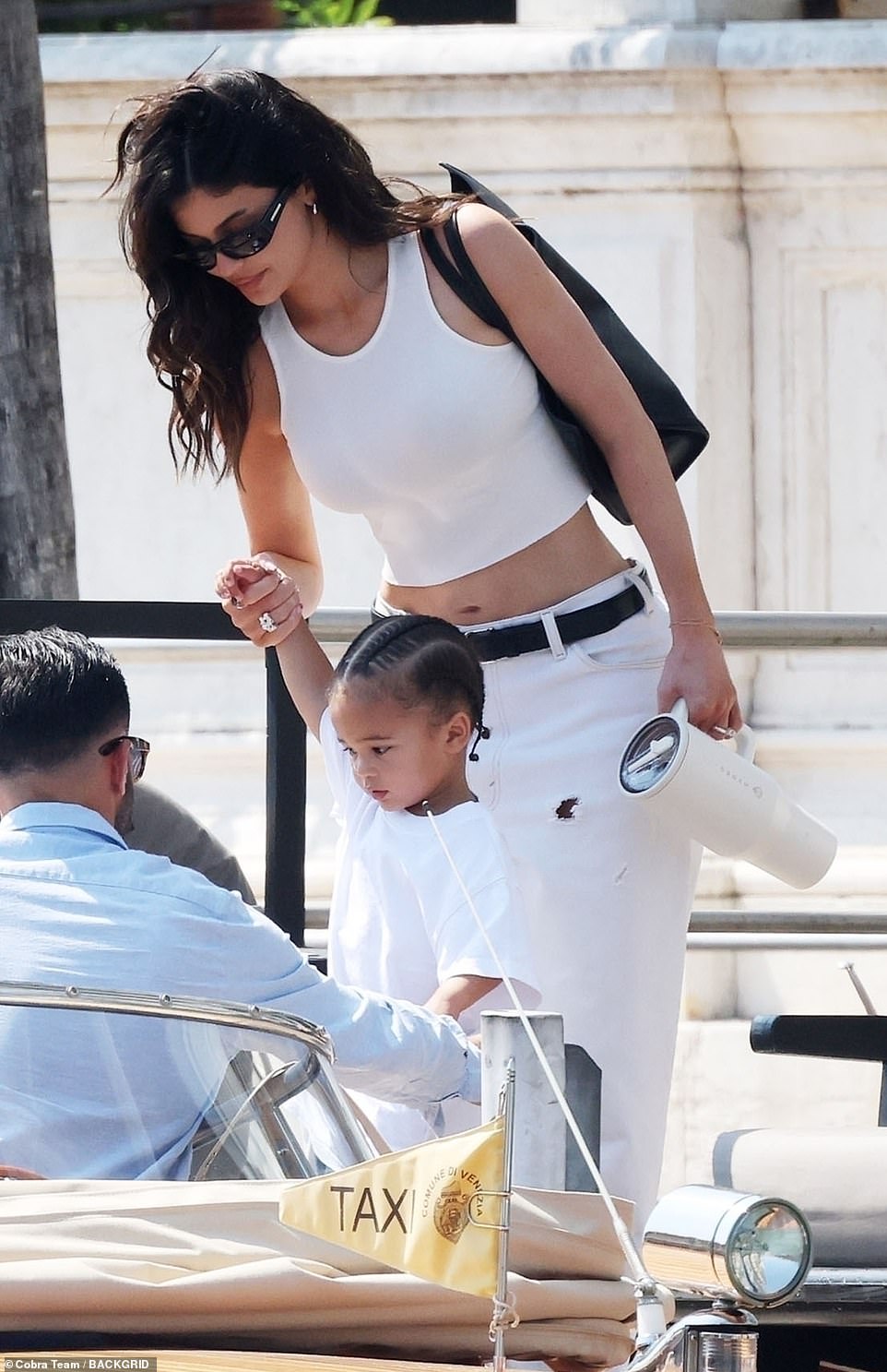 The 26-year-old mogul showed off her toned tummy in a white cropped top, which she paired with white jeans.