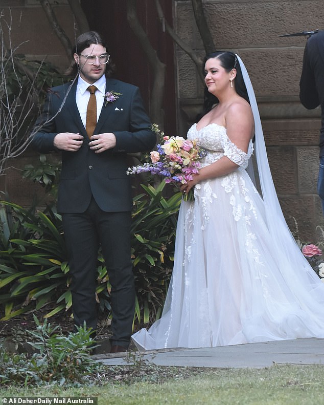 For the big day, Jake cut a dapper figure in a black suit and brown tie, while pinning a lilac corsage to his lapel.