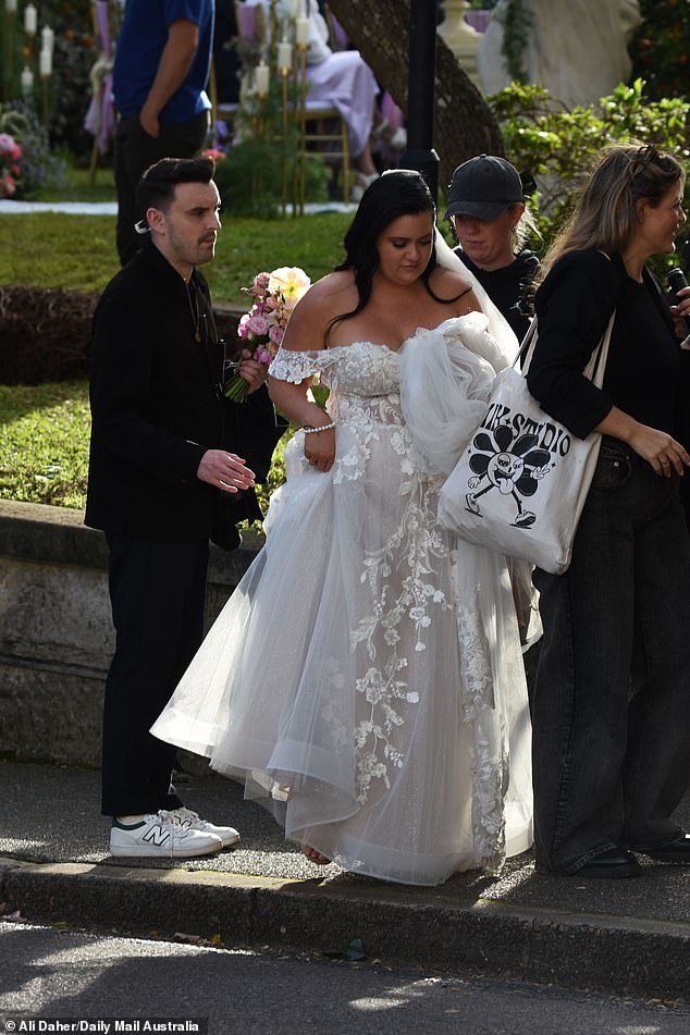 She styled her glossy black hair in a half-up, half-down hairstyle and placed a veil on top of her head to complete her elegant bridal ensemble.