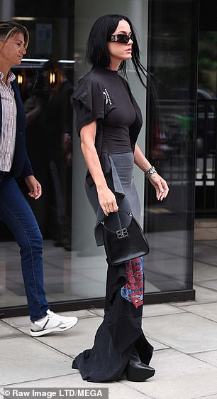 Katy increased her height with black leather boots and wore dark sunglasses to cover her eyes.