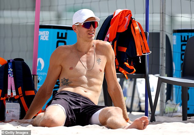 The Olympian was seen stretching on the sand before his training session with the Dutch volleyball team.