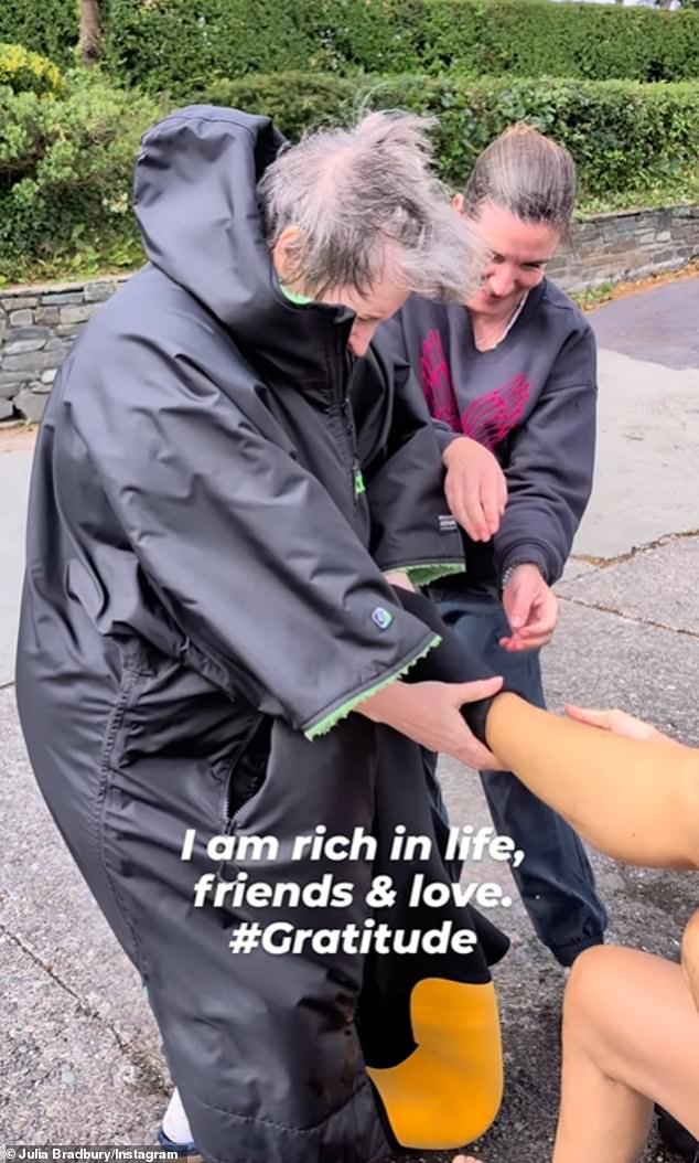 Julia wrote in the caption: 'I couldn't put on or take off my beautiful sustainable wetsuit @finisterre without my friends'