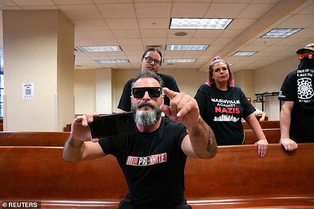 Jon Minadeo II, leader of the hate group Goyim Defense League, gestures as he disrupts a city council meeting in Nashville