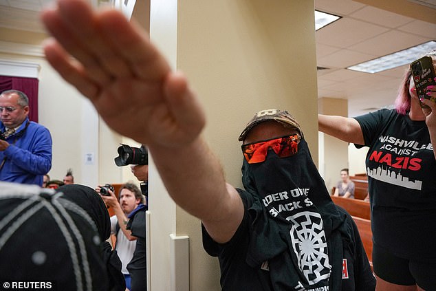 A member of the Goyim Defense League hate group gestures as he disrupts a city council meeting in Nashville