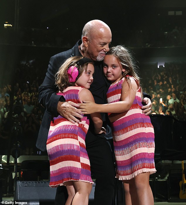 Joel gave his two girls a big hug before sitting back behind the piano.