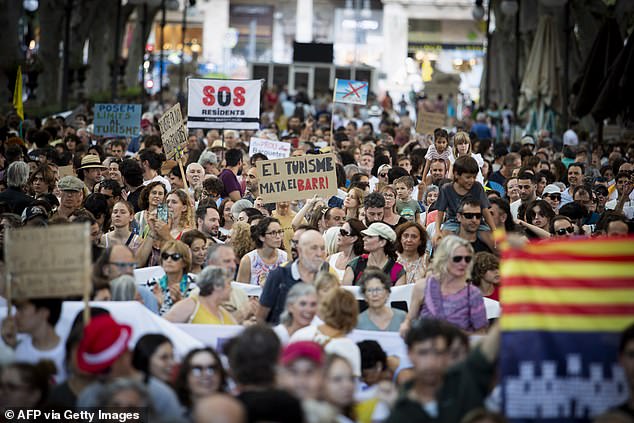 People take part in a demonstration to protest against overtourism and housing prices on the island of Mallorca in Palma de Mallorca on July 21, 2024