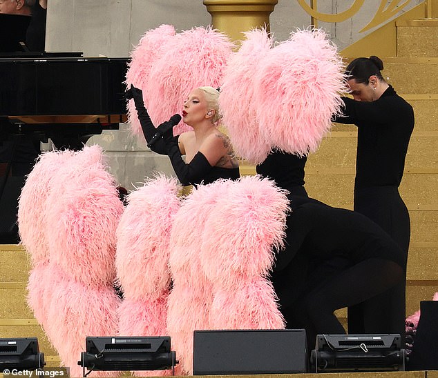 Gaga looked sensational in a strapless black top and shorts that featured a dramatic white feather bustle.