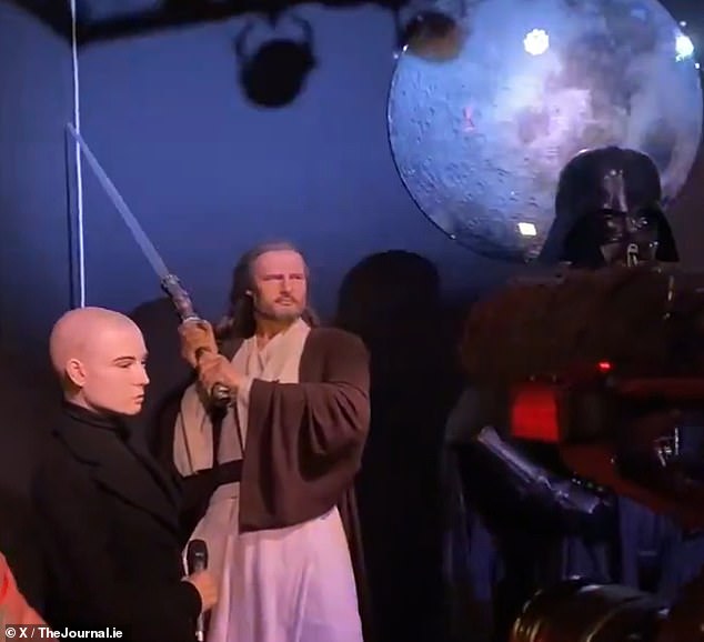 Even stranger, the artwork was placed alongside Liam Neeson in character as Qui-Gon Jinn and Darth Vader, both in Star Wars attire.