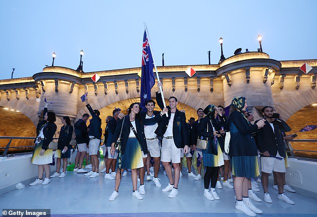 Members of the Australian team wave to the crowd of 320,000 spectators as they cruise down the famous channel early on Saturday morning.