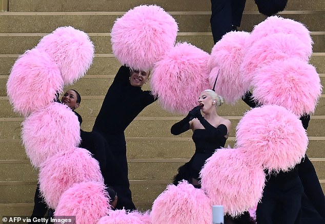 Lady Gaga is seen surrounded by pink heart-shaped feathers