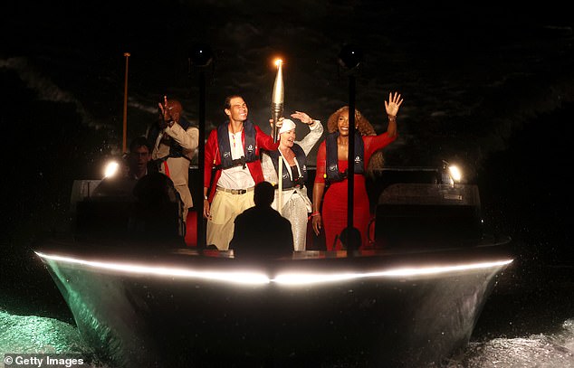 Rafael Nadal of the Spanish team, former American tennis player Serena Williams, American track athlete Carl Lewis and Romanian gymnast Nadia Comaneci carry the torch on a boat along the River Seine.