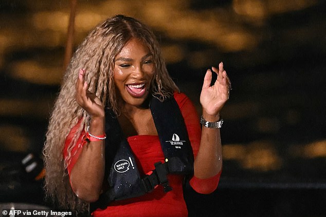 Serena Williams laughs and looks happy before being handed the Olympic torch for the opening ceremony.