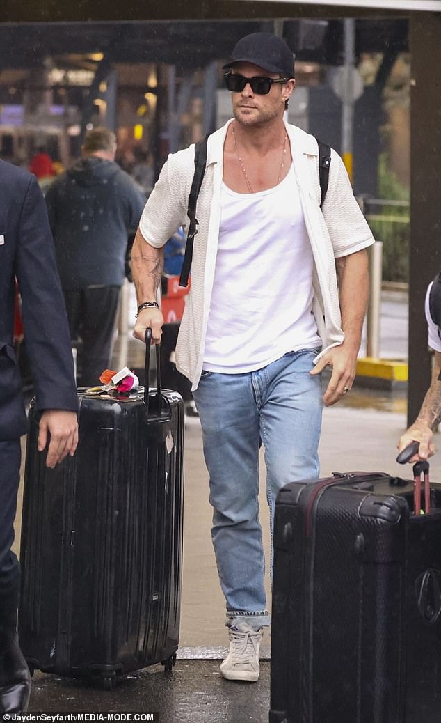 The 40-year-old actor strolled through the terminal in a simple white T-shirt under a lightweight, short-sleeved knit cardigan.