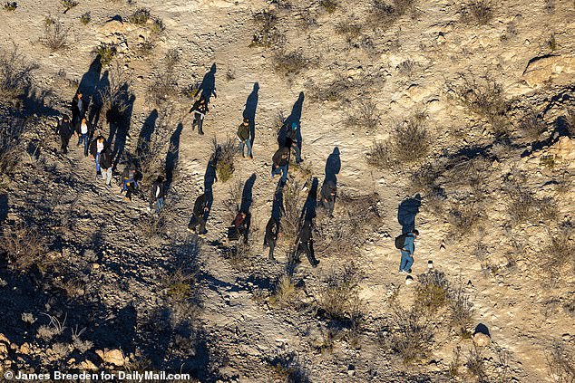 Illegal immigrants walk through the hills of Mount Cristo Rey in Sunland Park, New Mexico