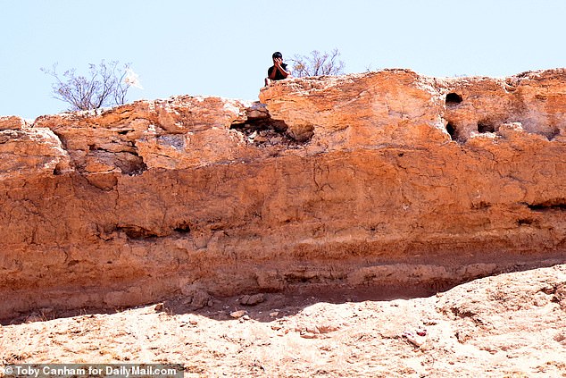 Young smuggler hides his face after seeing DailyMail.com camera taking his photo