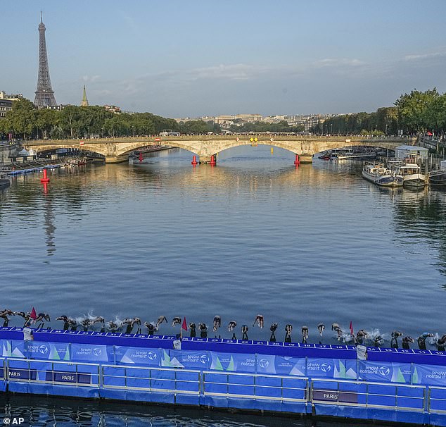 Athletes launch themselves into the River Seine from the Pont Alexandre III at the start of the first stage of the women's triathlon test event for the Paris 2024 Olympic Games