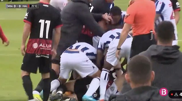 West Brom and Mallorca players try to separate the couple who fall to the ground fighting