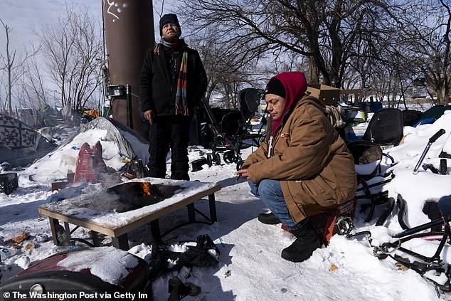 However, less affordable housing is being built, meaning rising prices have forced many people onto the streets. Cyrus Whittaker, left, and Debbie Orca sit by a campfire at the homeless encampment where they are living during record cold and snow in Oklahoma City on Feb. 16, 2021.