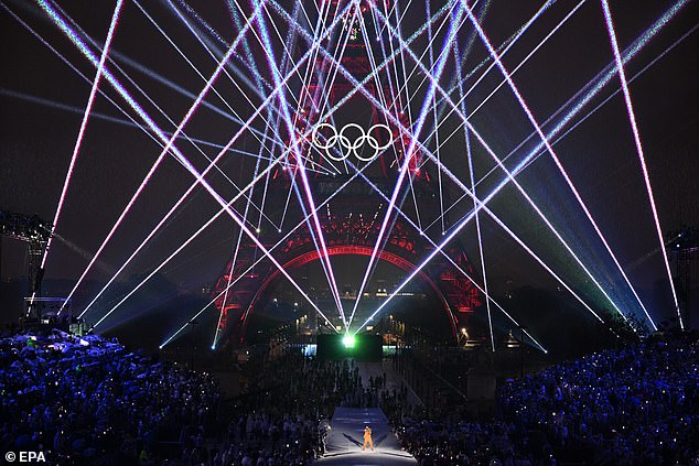 Multicoloured laser beams blast the rusty structure of the Eiffel Tower during the opening ceremony