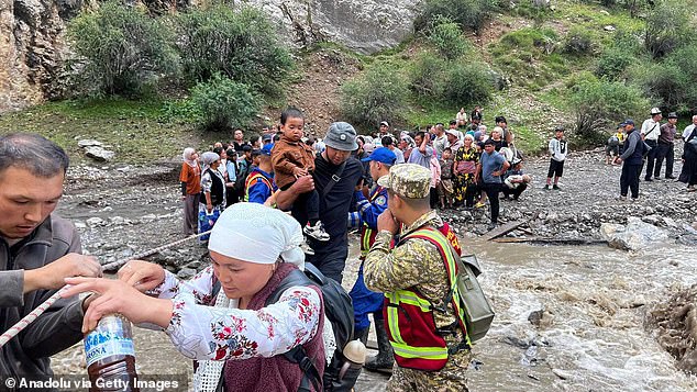 More than a dozen people have died from floods and landslides in Kyrgyzstan in recent months. Pictured: Search and rescue teams evacuate people to safety following heavy rains in the country