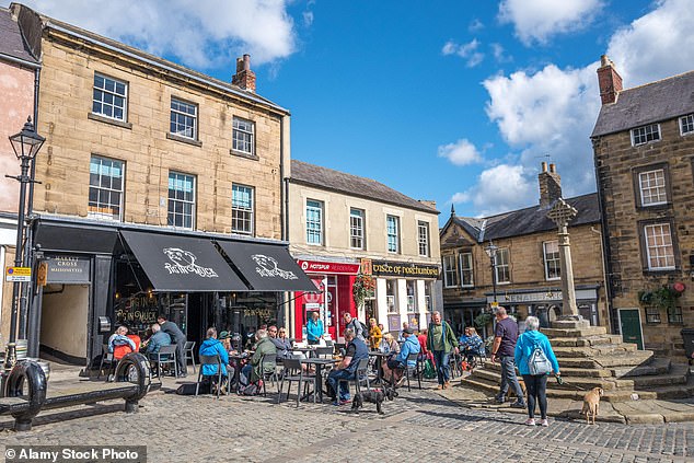 Visitors relax outside a cafe in the market town of Alnwick, Northumberland