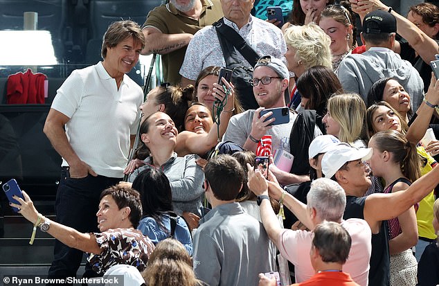 The 62-year-old actor was all smiles as he posed for photos on his way to his seat at the Bercy Arena.